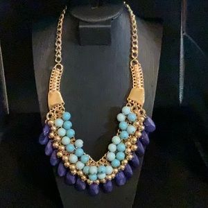 Adjustable gold tone with beads of dark blue, gold tone and light blue colors